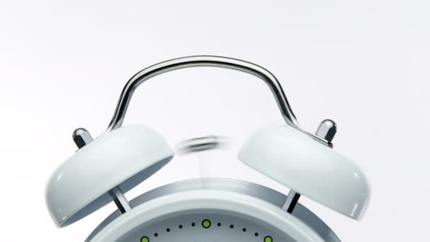 Zamknij dzwonek vintage biały budzik uruchamia alarm na białym tle - Materiał filmowy, wideo
