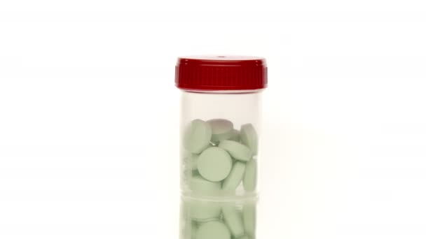 transparante Pillen fles met grote groene pillen geïsoleerd op witte 360 roterende - Video