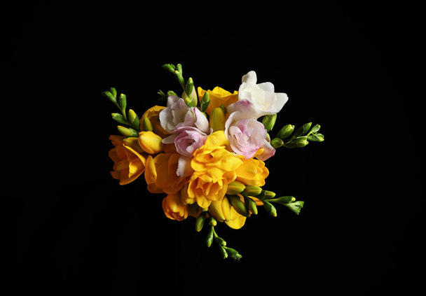 Bouquet of beautiful freesia flowers on black background, top view - Foto, Imagen