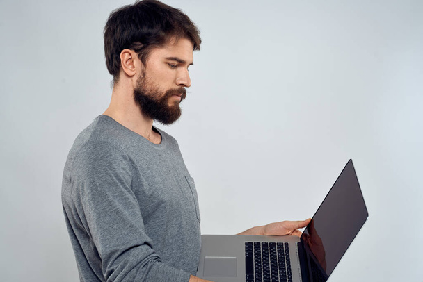 Συναισθηματικός άνθρωπος κρατώντας ένα φορητό υπολογιστή επιτυχία σύγχρονο στυλ εργασίας φως φόντο - Φωτογραφία, εικόνα