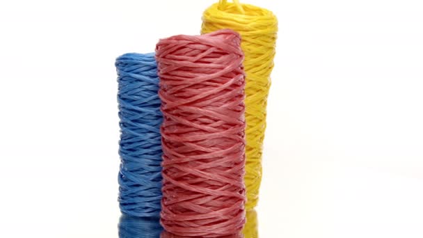Three skeins of colorful recycled plastic twine rotating on white background - Footage, Video