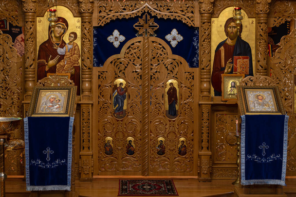 Православные иконы и иконостас крупным планом. Когда верующие входят в церковь, они целуют эти иконы и крестятся.. - Фото, изображение