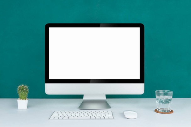 Computer met blanco witte kopieerruimte voor tekst, Mockup design desktop computer op kantoor op witte tafel met toetsenbord en koffiejong, Werkplaats concept, Cactus in pot. - Foto, afbeelding