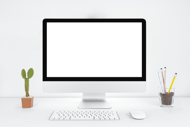 Комп'ютер з порожнім білим копіювальним простором для тексту, настільний комп'ютер Mockup в офісі на білому столі з клавіатурою і цукерками, концепція робочого місця, Cactus in pot. - Фото, зображення