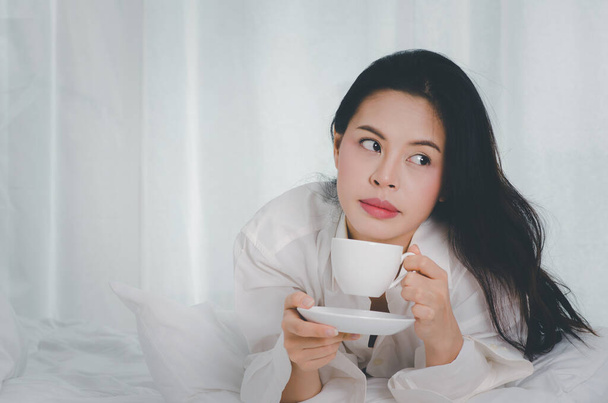 schöne junge Frau trinkt Kaffee im Bett - Foto, Bild