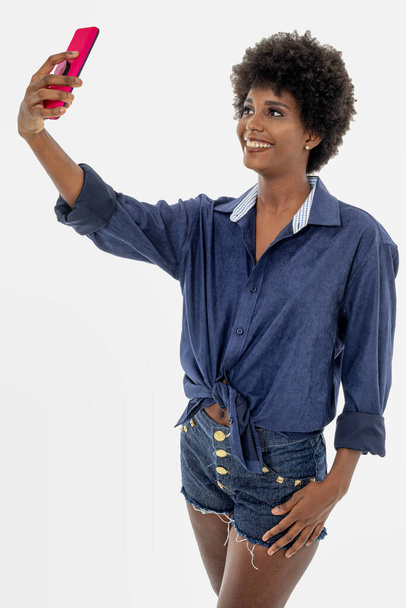 Mujer negra sosteniendo teléfono celular, aislado sobre fondo blanco. - Foto, Imagen