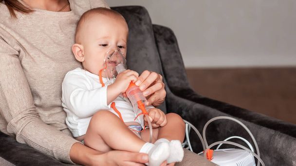 A baba légzésterápiára jár. Kézen fogva egy porlasztó maszkját otthon. asztma vagy tüdőgyulladás tünete, amit légzőszervi szintaktikai vírus okoz. Egészségügyi koncepció. - Fotó, kép