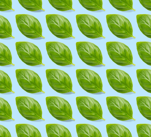 Italiaans Basilicum blad kruid naadloos patroon op blauwe achtergrond, Creatief naadloos patroon gemaakt van verse groene basilicum plat lay-out. Voedselingrediënt naadloos patroon. - Foto, afbeelding