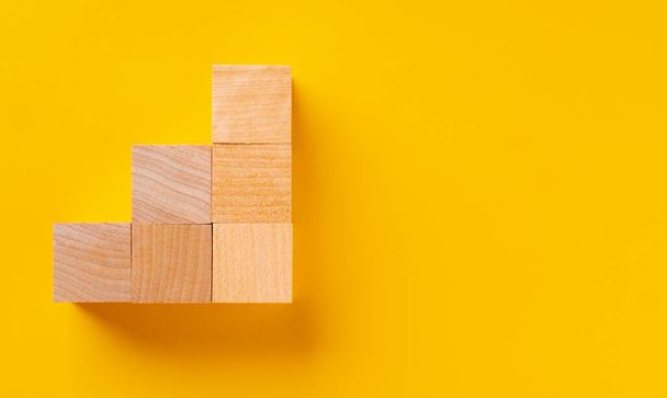 Top view of wooden cubes on yellow - 写真・画像