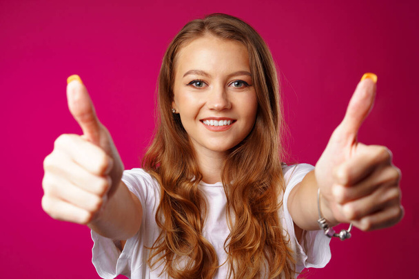 Young cheerful woman showing thumbs up sign - Valokuva, kuva