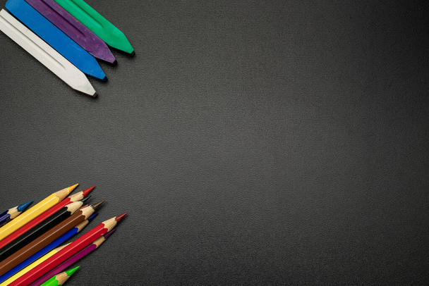 Black board background. Education accessories with colorful pencils, chalk, brushes on dark school blackboard. Banner Concept Back To School - Foto, Bild