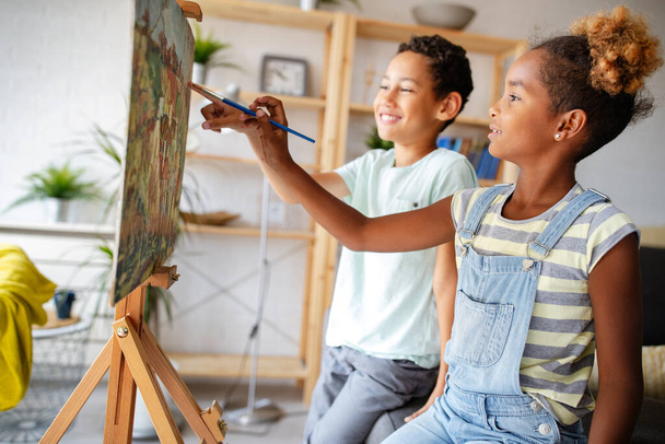 Słodkie dzieci malują razem. Edukacja, sztuka, zabawa i kreatywność. - Zdjęcie, obraz