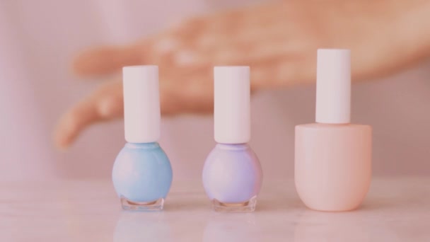 Scène de produits de beauté rose, mains féminines et bouteilles de vernis à ongles pour manucure française, vernis à ongles pastel coloré sur table en marbre, marque de maquillage et cosmétique - Séquence, vidéo