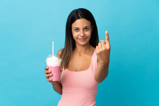 Młoda kobieta z truskawkowym shake 'iem robi nadchodzący gest - Zdjęcie, obraz