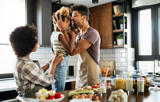 Szczęśliwa rodzina przygotowuje jedzenie razem w domu w kuchni - Zdjęcie, obraz