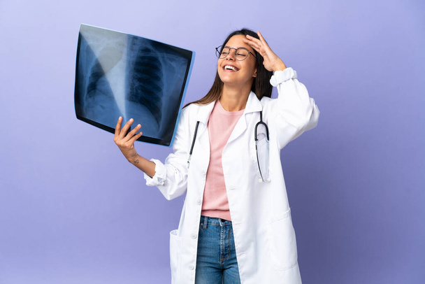 Молода лікарка, що тримає рентгенографію, багато посміхається
 - Фото, зображення