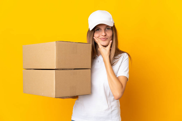 Young Slovak delivery woman isolated on yellow background thinking - Photo, Image