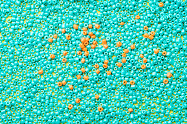 detailní záběr korálků, dvě barvy modré a oranžové. celý povrch je naplněn perlemi - Fotografie, Obrázek