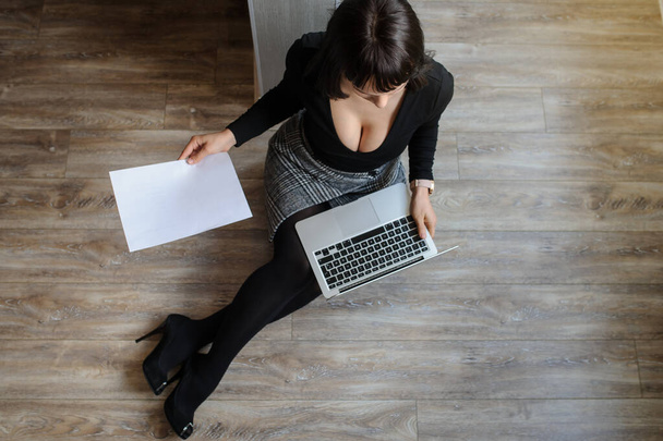 vista superior de uma morena quente em roupa de escritório sentado no chão e trabalhando no computador - Foto, Imagem