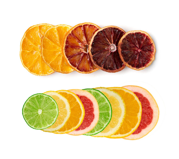 Suszone plastry pomarańczy i pomarańczy krwi izolowane na białym tle. Suchy cytryna, mandarynka i sycylijski pomarańczowy wiersz widok z góry - Zdjęcie, obraz