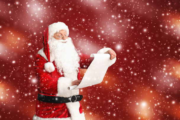 Άγιος Βασίλης ανάγνωση λίστα επιθυμιών με φόντο το χρώμα - Φωτογραφία, εικόνα