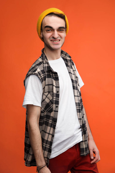Emotional young hipster guy on a bright orange background. - Fotografie, Obrázek
