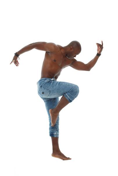 Athletic young black man in jeans and with a nude torso dancing isolated on white background. - Foto, immagini