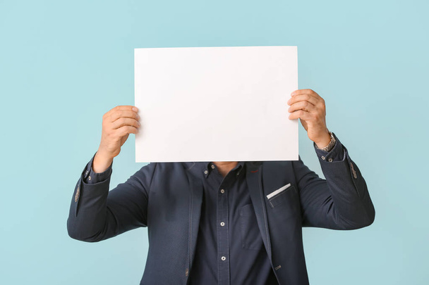 Man with blank paper sheet on light background - Foto, immagini