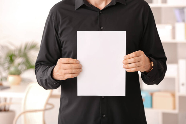 Man with blank paper sheet in office - Foto, imagen