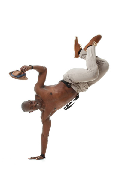Stylish black male dancer balancing on one hand isolated on white background. - Фото, изображение