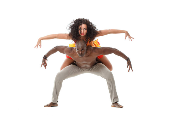 Hermosa chica blanca y hombre negro demuestran acrobacias bailando aislados sobre un fondo blanco. - Foto, Imagen