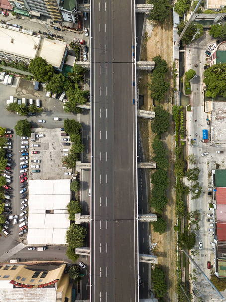 Blick von oben auf eine Hochstraße und einen Parkplatz. Antenne des Metro Manila Skyway auf den Philippinen. - Foto, Bild