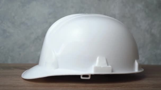 bílá helma leží na dřevěném stole - Záběry, video