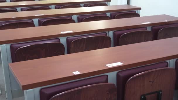 Közelkép babakocsi lövés lassan sétál át az üres egyetemi osztályteremben az összes üres fa asztalok során Covid 19 világjárvány - Felvétel, videó