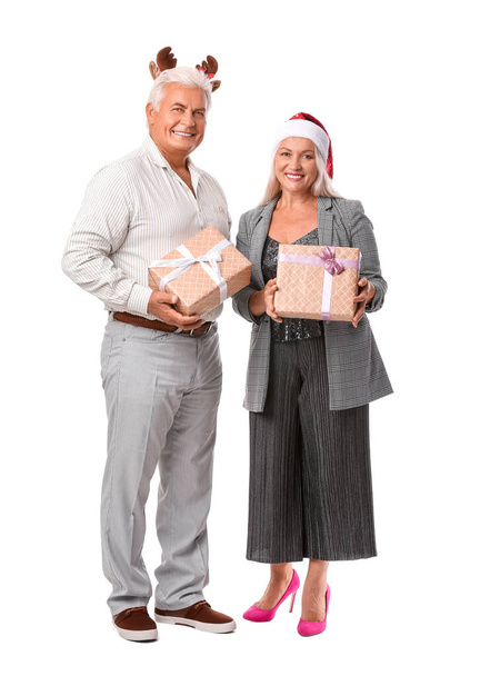 Elderly couple with Christmas gifts on white background - Photo, Image