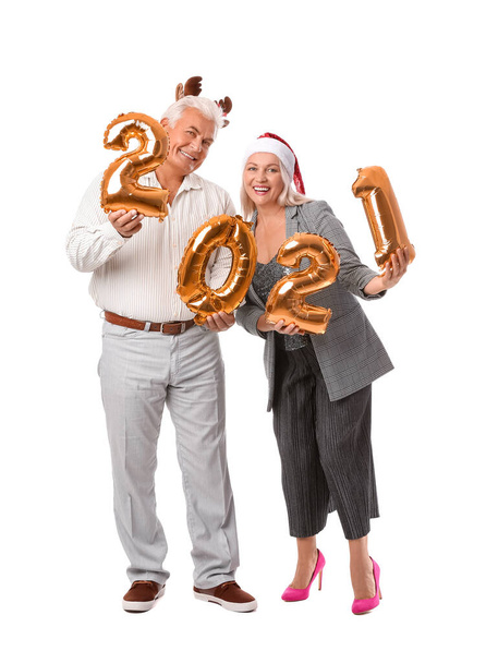 Iäkäs pariskunta, jonka luvut ovat 2021 valkoisella taustalla. Uusi vuosi juhla - Valokuva, kuva