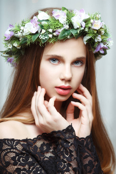 Portrait of a young beautiful girl with a delicate wreath on her head indoors. - 写真・画像