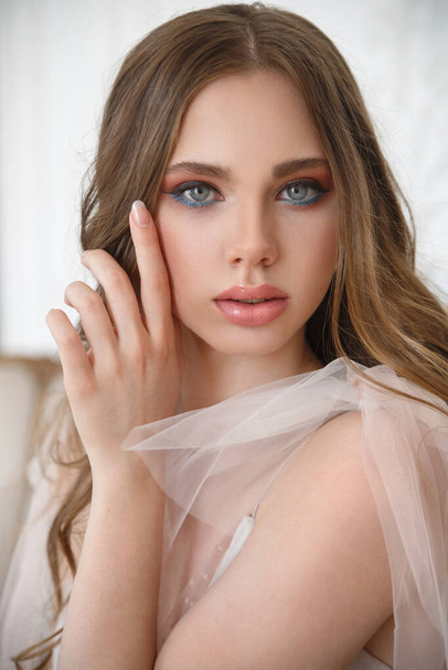 Beauty portrait of a young girl of the bride with an expressive look in a delicate dress in the interior. - Foto, Imagen