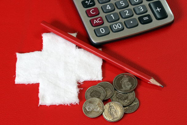 Монети Швейцарії з калькулятором і олівцем на червоній шкірі PVC з білим хрестом тканини, поставлені як швейцарський національний прапор. Франц Швайз гроші, концепція фінансів.. - Фото, зображення