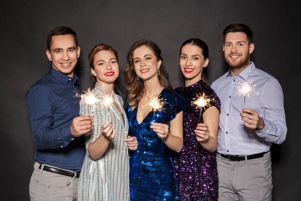 happy friends in party clothes with sparklers - Zdjęcie, obraz