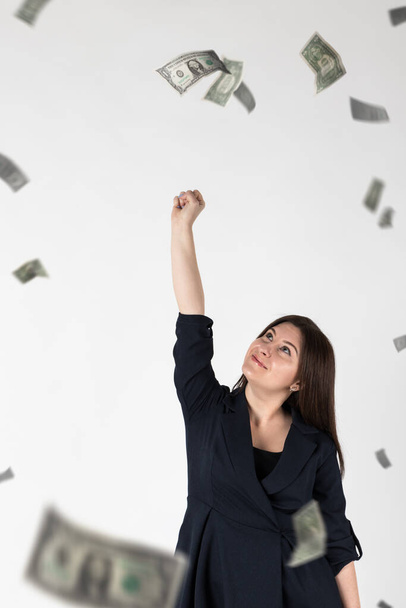 Rejoicing. Woman in blue and falling dollar banknotes. Success, currency and lottery concept. - Foto, Bild