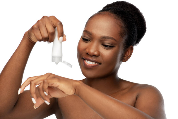 smiling african american woman with moisturizer - Фото, зображення