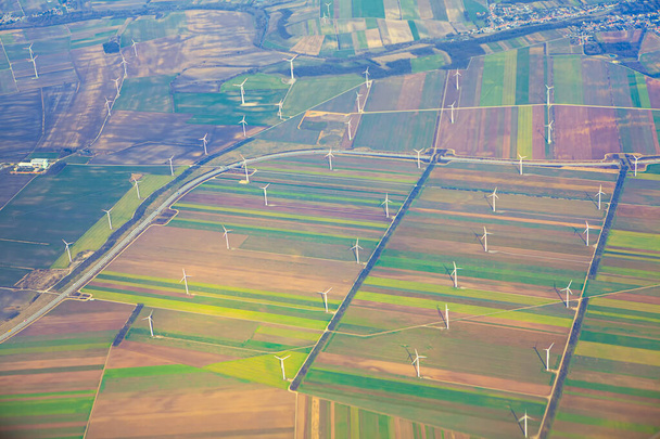 緑のフィールド上の風力タービン、空中ビュー。風車は郊外に電力を供給するのに十分な電力を発電できる。 - 写真・画像