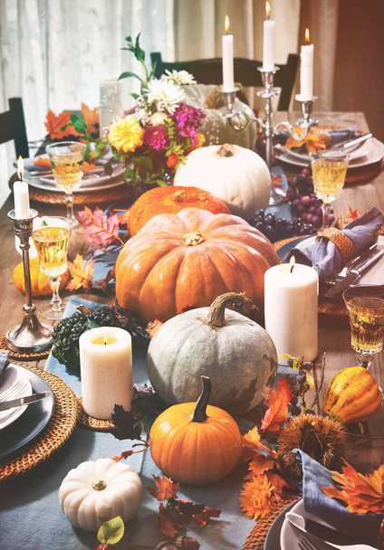 Thanksgiving celebration traditional dinner setting food concept. Festive decoraded table with pumpkins, vegetables, flowers and candles - Foto, Bild