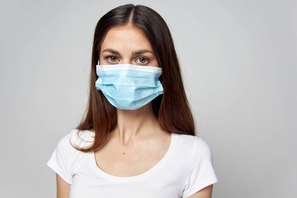 Woman in medical mask Look forward white t-shirt cropped view - Foto, Imagem
