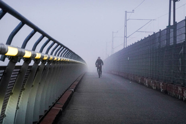 Стокгольм, Швеція Велосипедист на мості Арат у ранковому тумані.. - Фото, зображення