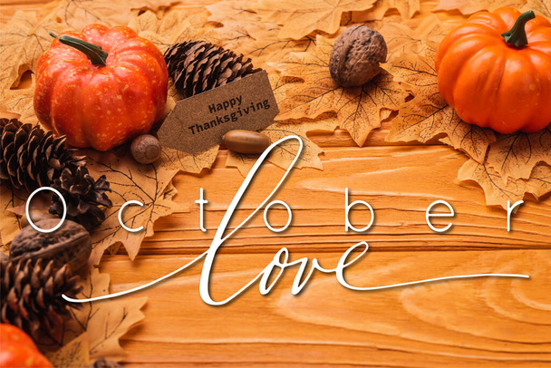 pumpkin, autumnal decoration and happy thanksgiving card near october love lettering on wooden background - Foto, Bild