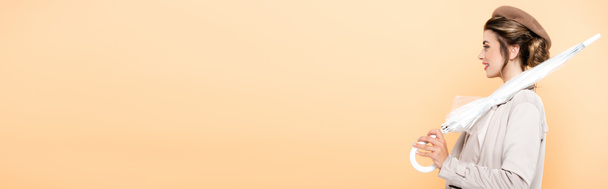 вид сбоку триумфальной женщины в осеннем наряде, держащей складную пумбрию на персике, заголовок сайта - Фото, изображение