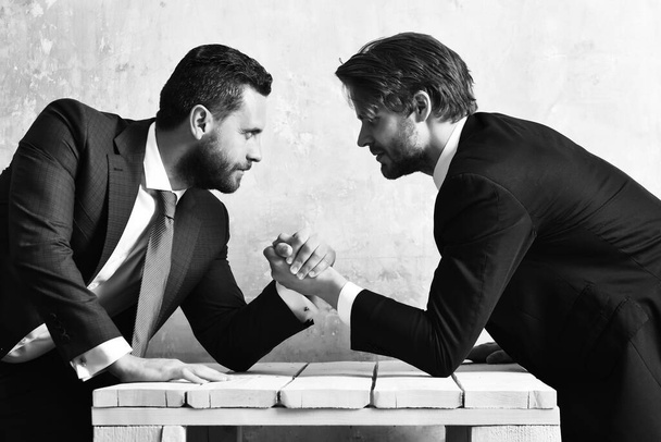 Business competition. Two serious businessmen arm wrestling - Фото, зображення