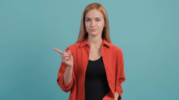 Verstoorde vrouw die tonen nee met haar vinger poseren op turquoise achtergrond. - Video